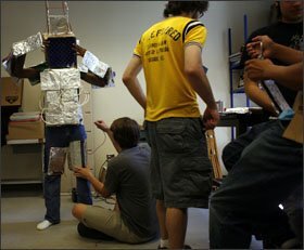 George Mikell, 16, gets suited up by classmantes to dance as a robot during the talent show at the Family Fun Tent in the park.