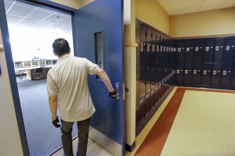 A school janitor opens the door to a staff room inside Bothell High School, in the Northshore school district in Bothell, Wash.