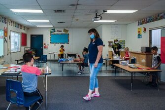 Three students in the district child-care program work on a remote-learning project last month at the Chase Avenue School.