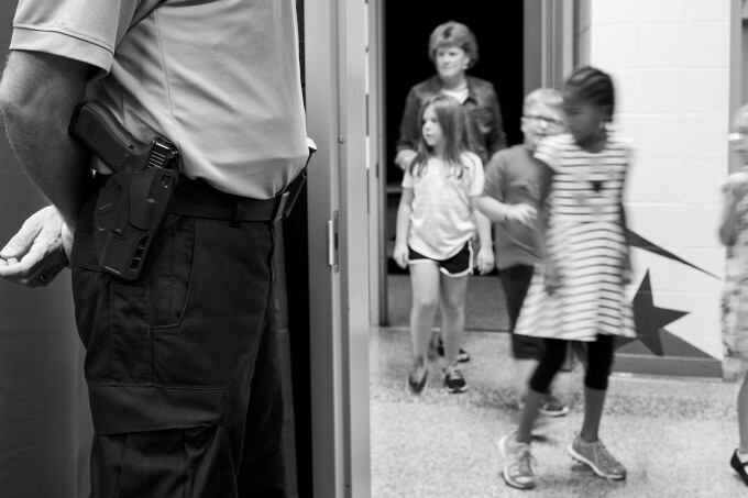 Brian Hall, a community safety officer assigned to elementary schools in Prince William County, Va., keeps watch over students at Ashland Elementary School in Manassas, Va., last year.