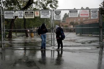 Students wait outside of John Marshall High School in Los Angeles after being let out early following an announcement of a districtwide closure caused by the coronavirus threat Friday, March 13.