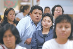 Victor Aki and his wife, Rosario, center, listen to organizers with the Coalition Agaist Militarism in Our Schools, in Culver City, Calif., this month.