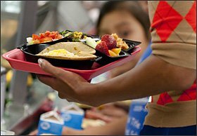 First lady Michelle Obama holds a school lunch that meets new federal nutrition standards at Parklawn Elementary School in Alexandria, Va., last week. Mrs. Obama ate lunch at the school to help draw attention to the U.S. Department of Agriculture's new regulations for school meals.