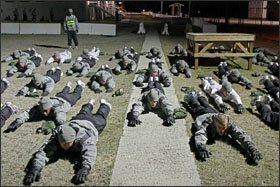 Soldiers enrolled in the school participate in daily physical training before dawn.