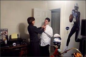 Andrew Van Cleave gets help with his tie from his mother, Mary Van Cleave, before his graduation at Vanderbilt University.
