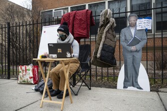 A teacher sets up her laptop outside of Suder Montessori Magnet Elementary School to begin virtual classes in solidarity with pre-K educators forced back into the building in Chicago on Jan. 11, 2021.