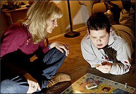 Jacob Winkelman, 9, plays a board game with his mother, Sandee. Next week, the family’s case over special education legal representation goes before the U.S. Supreme Court.