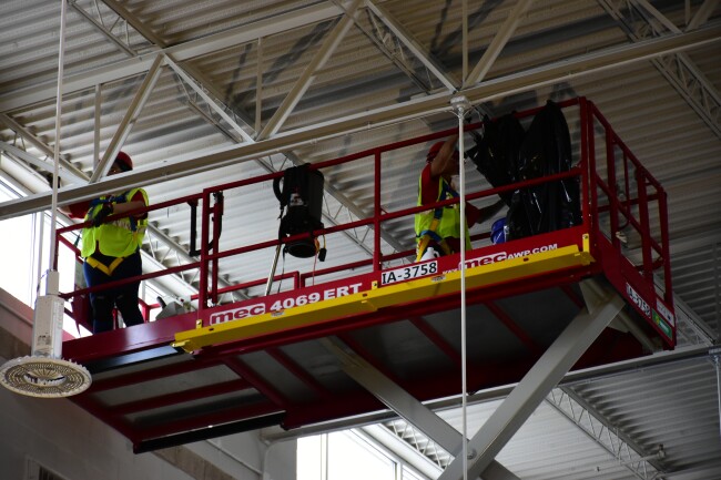 Two workers fix smoke-related damage high up near a ceiling in one of the Grafton buildings.