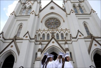 The last few St. Vincent’s Academy students look over their shoulders before entering The Cathedral of St. John the Baptist at the beginning of their commencement in Savannah, Ga.