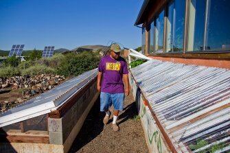 Gardening and home economics teacher Tyrone Thompson checks on the school's greenhouses. Local farmers teach children how to grow organic crops in the desert greenhouses.