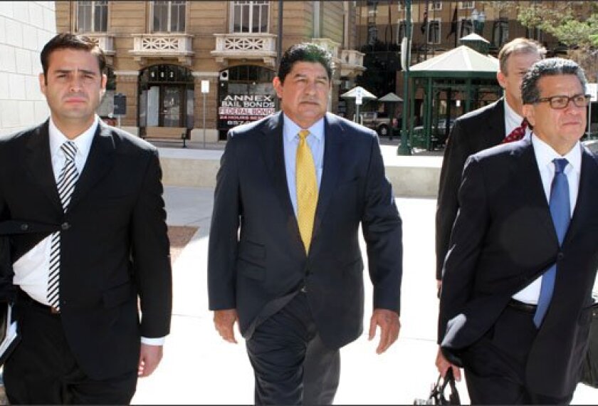 Lorenzo García, the former superintendent of the El Paso, Texas, schools, is flanked by his lawyers as he walks to U.S. District Court in El Paso on Oct. 5. He was sentenced to spend 3½ years in prison, and ordered to pay fines and restitution, for conspiring to manipulate scores on state tests and other misdeeds. As part of his restitution, he will have to return $56,500 in bonuses that he received for students’ improved performance.