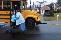 Sarah Garvin kisses her mother, Melodee, before boarding a school bus in Stafford County, Va. The family would like Sarah, who has Down syndrome, to be accompanied in school by Satin, her companion dog. But the school district says the dog is not necessary as part of Sarah's individualized education program.