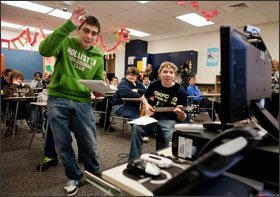 Alex Grodzicki, left, 15, and James Beaupied, with guitar, 16, both 10th graders at Oxford High School in Oxford, Mich., perform a song that is broadcast via teleconference to students in Ningbo Secondary School in China’s Zhejiang province.