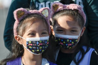 Masked students wait to go their classrooms on the first day of school at Enrique S. Camarena Elementary School Wednesday, July 21, 2021, in Chula Vista, Calif. The school is among the first in the state to start the 2021-22 school year with full-day, in-person learning.