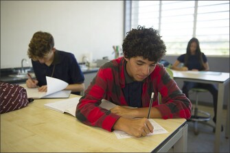 Jeremy Hernandez Diaz, writes in his 11th grade class at Escuela Jesus T. Piñero in Cidra, on the first day of school. Unlike some of his peers, Jeremy plans to stay in the island’s schools. “I don’t want to leave my family behind,” Jeremy said. “I’m not that kind of person.”