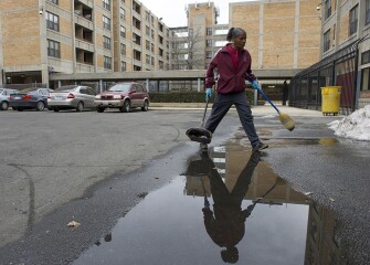 Charlene Burwell, a resident and maintenance worker at Potomac Gardens, tends to the trash outside of the building. The complex has been known to some city residents as the site of violence over the years, but that doesn’t bother Burwell. “I don’t live out here,” she said. “I live in there,” she added, gesturing toward her apartment.