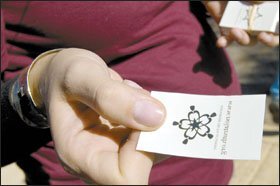 Ms. Moody, hands out temporary tattoos to parade-goers in an effort to raise awareness of—and find students for—the new charter school.
