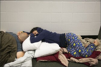 Yaya Lopez holds her fiance, Howard Lopez, while they sleep in a hallway at John Hopkins Middle School on Sept. 10, in St. Petersburg, Fla. The school filled classrooms and hallways with people evacuating before Hurricane Irma made landfall.