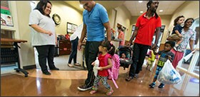 Head Start employee Melissa Gill, left, welcomes students and parents during the first week of school at the Skelly campus of the program’s Community Action Project in Tulsa, Okla.