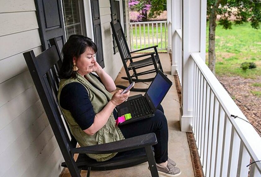 Lani Gray, a teacher in Anderson, S.C., reviews e-learning homework material on her devices. In addition to academic content, some schools are incorporating social-emotional learning lessons into students' online school experience.