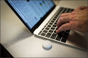 An iBeacon, a battery-powered Bluetooth device, sits next to Lauer’s laptop. The principal uses beacons and an app called Proximity Log to track how he divides his time between his office and classroom visits.