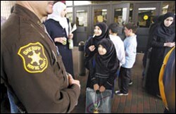 As hostilities begin in Iraq, a Wayne County, Mich., deputy sheriff stands guard March 21 at the Islamic Institute of Knowledge, a private school in Dearborn with many students of Iraqi descent. 