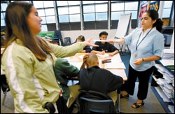Teacher Monica Galvan, right, hands off papers to support teacher Amy Miranda during a math and history class for English-language learners at Gompers Charter Middle School in San Diego.