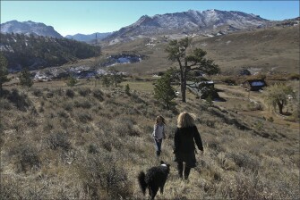 Corinne and Lisa, with Lisa’s dog, Soleil, hike down a hill.