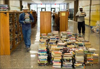 Workmen remove books from the flood-damaged Forest Brook Middle School in Houston last week.