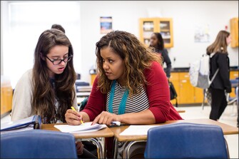 Ashlee Clark works with sophomore Mary Madison Bradley during class at her Greensboro, N.C., school. Clark was doing animal research in graduate school before joining the school system as a chemistry teacher.