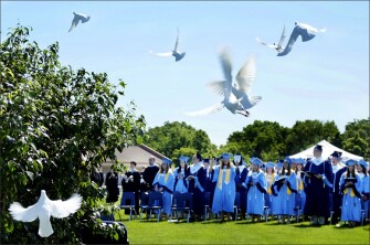 Millbrook High School graduates watch as white doves take flight at the end of the school’s commencement ceremony in Winchester, Va.