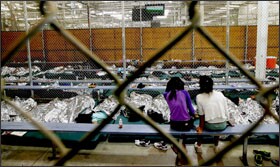 Two girls watch a World Cup soccer match on a television from a holding area where hundreds of mostly Central American immigrant children are being processed and held at a U.S. Customs and Border Protection facility in Nogales, Ariz.