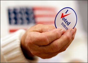 A sticker is handed to a voter in Waterville, Maine, on Election Day.