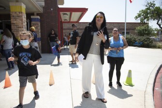 Boone Elementary School principal Manuela Haberer directs students and parents in the pick-up line at the conclusion of the school day on May 19, 2022 in San Antonio, Texas.