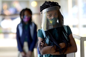 Victoria Dickens wears a mask and face shield as she waits for her class assignment at Summit Elementary School in Summit, Miss., on Thursday, Aug. 5, 2021, during the first day of the 2021-22 school year for students in the McComb School District. The school district is requiring face masks on buses and campuses this school year.