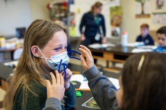 Harper, 10, wears a mask with pipe cleaners sticking through it to experience the feeling of whiskers as part of Sophie Girard’s science class on March 30, 2023.