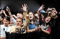 Young people cheer at a rock concert for President Bush.