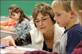 South Dakota Counts math specialist Roxane M. Dyk works with Colin Lagge on a math problem in a 4th grade class at Corsica Elementary School.