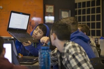 Johnny Rivera discusses an algebra problem with classmates at iLEAD Academy.