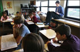 Senior Sean Collins, near window, works on dissecting Adolf Hitler’s Mein Kampf during his IB history class at the high school.