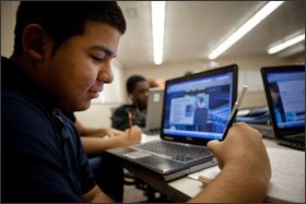 Avelino Penaloza, 16, takes notes while using a laptop to watch a video lecture on homeostasis at Ottawa Hills High School in Grand Rapids, Mich. He is participating in a hybrid classroom, which blends face-to-face and online learning.