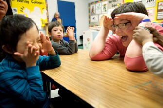 Special education teacher Elizabeth Rosenberry, right, encourages student Jesus Torres-Tiamani, left, to make eye contact, at PS4Q in the borough of Queens, N.Y. Also pictured is student Ian Tokay, center.