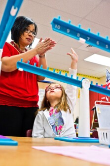 Nena Hupp helps Chase Toler in her class at Worthington Elementary School. Students in the Howard County, Md., district are being taught math concepts at an earlier age.