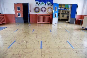 Blue stickers showing a safe distance of at least one meter are displayed on the floor ahead of a visit of the French President Macron at the Pierre Ronsard elementary school on Tuesday, May 5, 2020, in Poissy, outside Paris. Starting from May 11, all French businesses will be allowed to resume activity and schools will start gradually reopening.