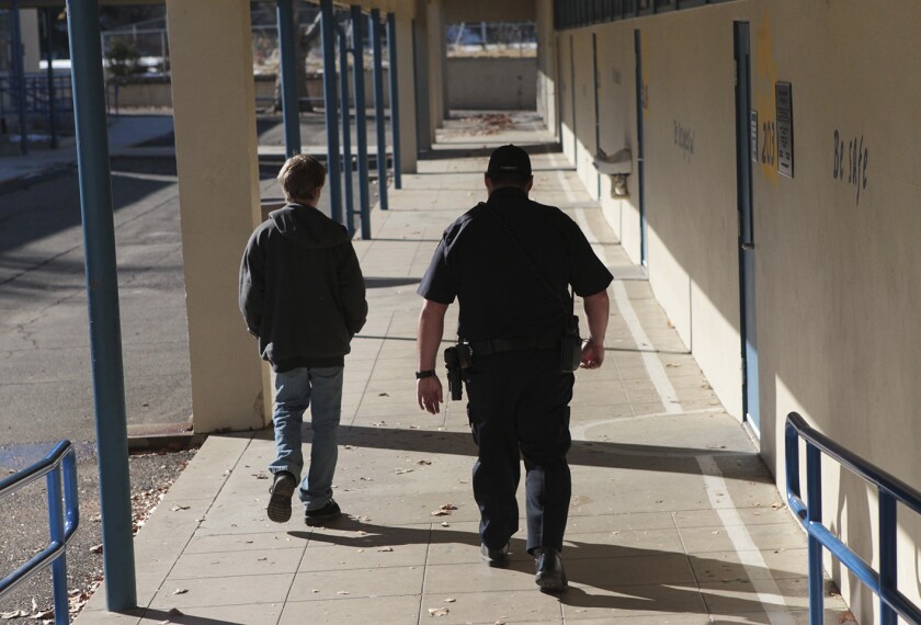 A school resource officer in Anderson, Calif., walks a middle school student back to class on Dec. 9, 2013.