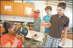 From left, freshmen Ashley Parks, Jeff Bader, and Joe Purze work on an experiment in Gabe de la Paz's physics lab.