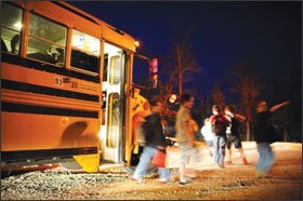 Children get off the bus at a drop-off point outside Camdenton. The buses travel to designated locations throughout the 372-square-mile school district where parents are waiting for their children.