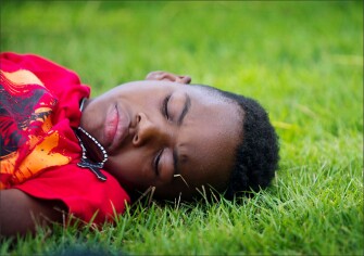 VLA student Jevron Hobbs Jr. rests on the grass outside of his hotel room after visiting the Sosua dump where homeless people sort garbage to be sold for about a dollar a day.