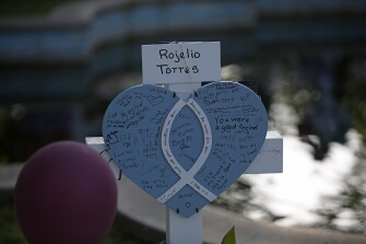 Rojelio Torres' cross stands at a memorial site for the victims killed in this week's shooting at Robb Elementary School in Uvalde, Texas, Friday, May 27, 2022.