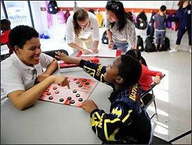 Students play checkers at the Sheridan Park field house in Chicago. Many local facilities opened their doors to give children places to go during school hours.